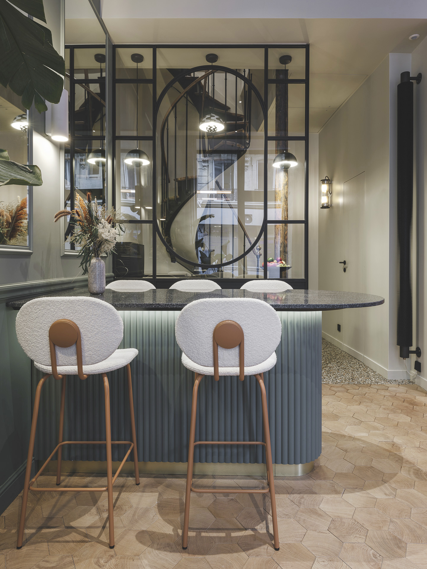 Par un jeu de reflets, grâce aux miroirs et à la finition du plateau de la table du bar, cet espace lumineux sert aussi bien à la collaboration informelle - le temps d'un café ou d'un en-cas - qu'à la réception de clients.